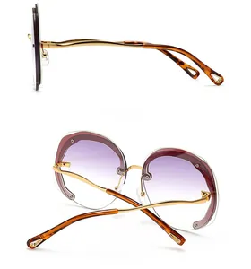 Detail of round rimless sunglasses with purple gradient lenses and gold metal temples