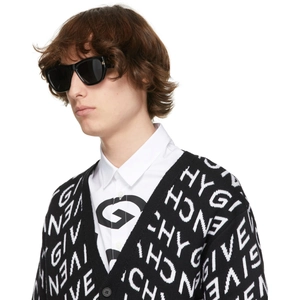 Detail view of retro cat-eye sunglasses paired with a monochrome knitted logo cardigan