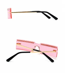Detail view of pink rimless sunglasses with gold temples and rhinestone-studded lenses