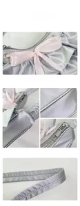 Detailed close-up of light purple satin handbag with pink ribbon bow and metal zipper