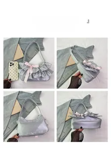 Detail view of silver satin shoulder bag featuring ruffles and pink silk bows on four sides