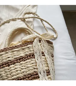 Close-up of woven straw bucket bag featuring a lace bow and drawstring lining detail