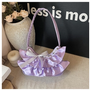 Detail of lavender satin tote bag with ruffled edges and white silk bow accent