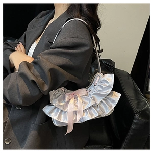 Detail of silver metallic shoulder bag featuring layered ruffles and a pink silk bow