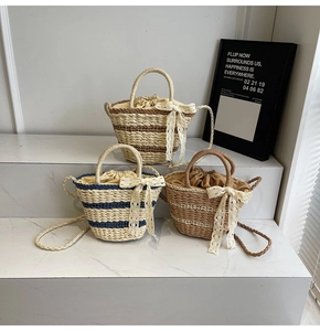 Detail of woven straw bucket bags with lace bows and drawstring lining in three colors