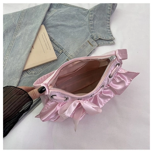 Detailed interior of a pink satin handbag featuring ruffle trim and silver zipper close-up