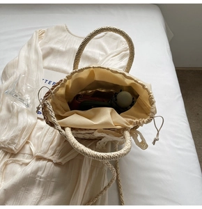 Straw bucket bag interior view showing large storage capacity with lace bow details