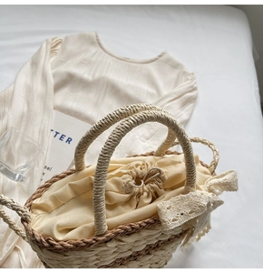Close-up of woven straw bucket bag with lace bow detail and drawstring liner