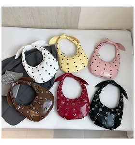 Six half-moon handbags in vibrant colors featuring eyelet rings and knotted bow handles
