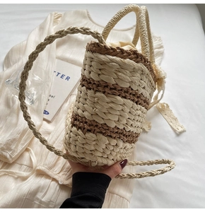 Detail of woven straw bucket bag with drawstring liner and white lace bow decoration