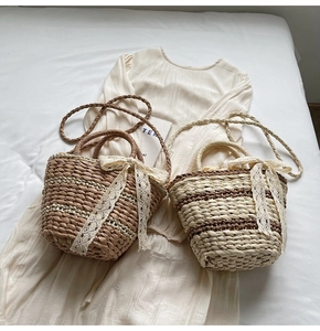 Detail of woven straw bucket bags featuring lace bows and dual-tone striped textures