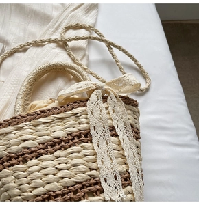 Detailed macro view of woven straw bucket bag with delicate lace bow and bicolor texture