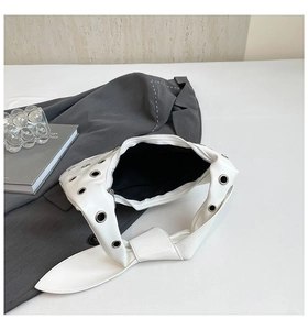 Detailed macro view of white PU leather tote with silver eyelets and black inner lining