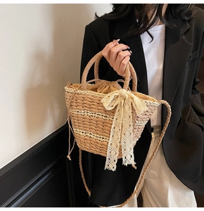 Close-up of woven straw bucket bag with lace bow and drawstring closure detail