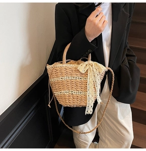 Detail of hand-woven straw bucket bag with lace bow and drawstring liner shown on model