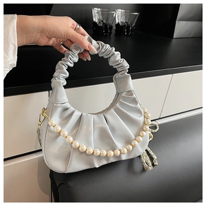 Detail of light blue cloud bag with pleated handle and white pearl decorative chain