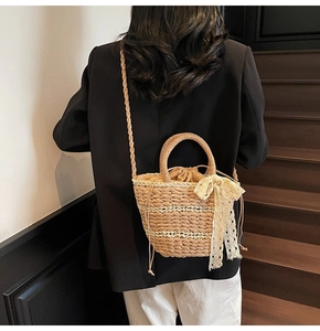 Detail of woven straw bucket bag with lace bow and drawstring inner lining