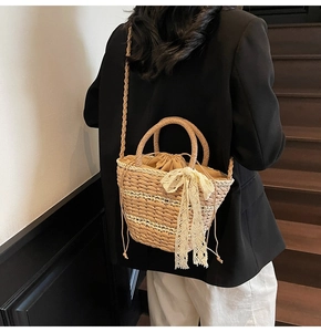 Detail of woven straw bucket bag with white lace bow and drawstring inner bag