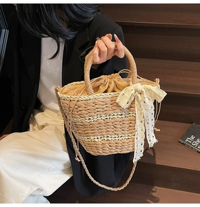 Detail of woven straw handbag featuring intricate lace bow and drawstring inner lining