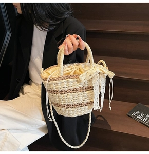 Detail of woven straw tote bag with white lace bow and adjustable drawstring lining