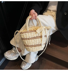 Detailed straw bucket bag with lace bow and drawstring inner bag for a summer casual look