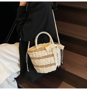 Detail of woven straw bucket bag with drawstring liner and lace bow decoration