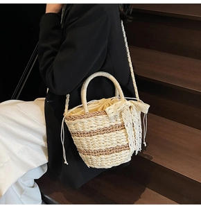 Detail of woven straw bucket bag with lace bow decoration and drawstring closure