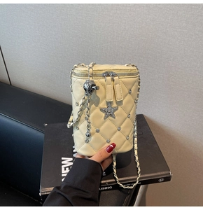Détail du sac bandoulière matelassé crème avec étoiles strass et chaîne argentée