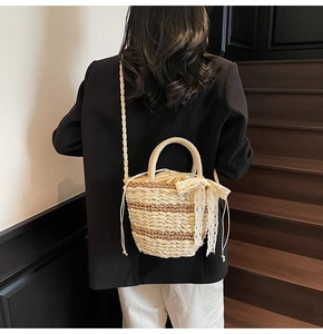 Detail of woven straw bucket bag with lace bow decoration and drawstring lining