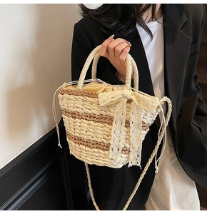 Detail of woven straw bucket bag featuring beige lace bow and drawstring fabric liner