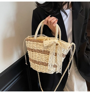 Detail of woven straw bucket bag with lace bow and drawstring inner lining for women