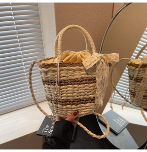 Detail of woven straw bucket bag featuring lace bow accent and drawstring lining