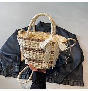 Detail of woven straw bucket bag featuring lace bow and striped pattern for summer