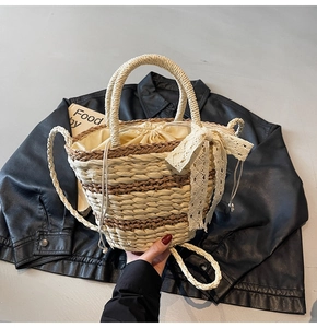 Close-up of a woven bucket bag featuring a white lace bow and canvas drawstring liner
