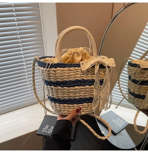 Detail of woven bucket bag with blue stripes, white lace bow, and drawstring lining