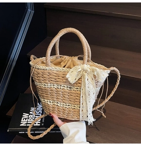Detailed texture of hand-woven straw bucket bag with lace bow and drawstring lining