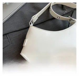 Detail of premium PU leather stitching and adjustable strap on the cream crescent bag