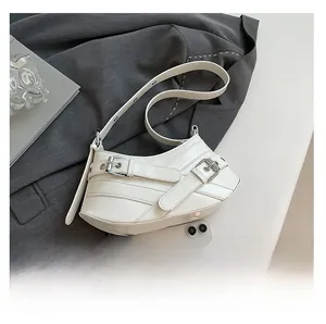 Detail of cream leather hobo bag with double metal buckles and wrinkled texture on suit
