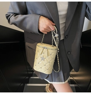 Détail d'un sac seau matelassé avec strass en étoile et bandoulière chaîne