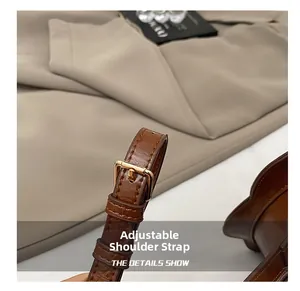 Détail macro de la bandoulière en cuir marron avec boucle en métal doré poli