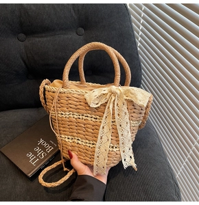 Detail of hand-woven straw bucket bag with oversized lace bow and stripe texture