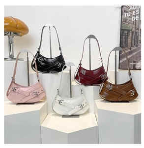 Group of crescent bags in five colors with decorative buckle straps on display