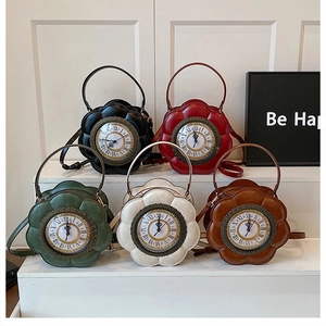 Group view of vintage clock-shaped bags in five colors on a tiered white display