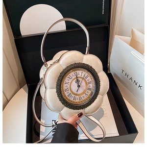 Detail of vintage white petal-shaped handbag with decorative clock face in a gift box