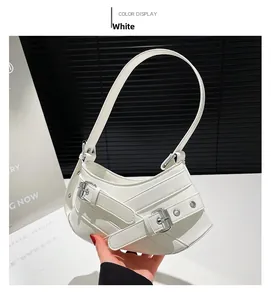 Detailed view of white crescent shoulder bag with crisscross straps and silver buckles