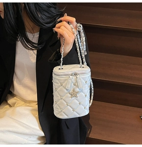 Détail du sac seau matelassé avec clous en étoile et bandoulière chaîne argentée