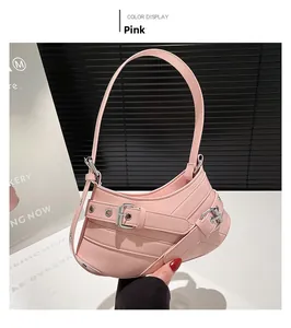 Close-up of pink crescent shoulder bag featuring adjustable silver buckle strap details