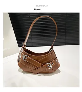 Detail of a brown leather crescent shoulder bag featuring stylish silver metal buckles