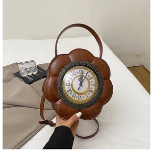 Close-up of vintage brown clock-shaped handbag with petal edges on a white bed
