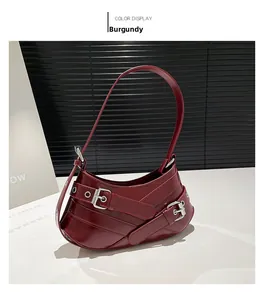 Detailed close-up of wine red patent leather shoulder bag with silver buckle straps